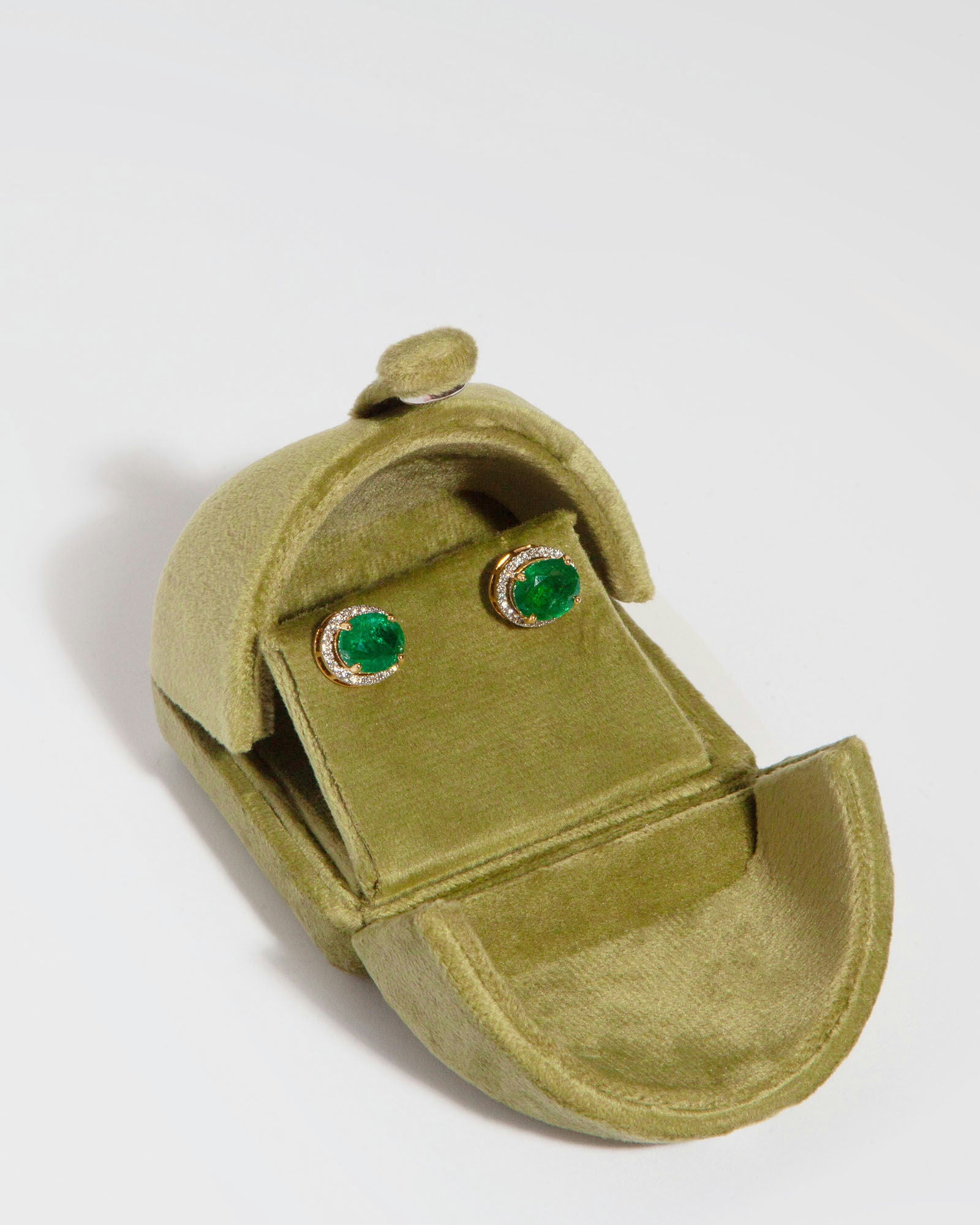 Stud earrings in 14K yellow gold featuring two oval mixed-cut natural emeralds (6.60 ct) and 51 natural diamonds (0.40 ct).