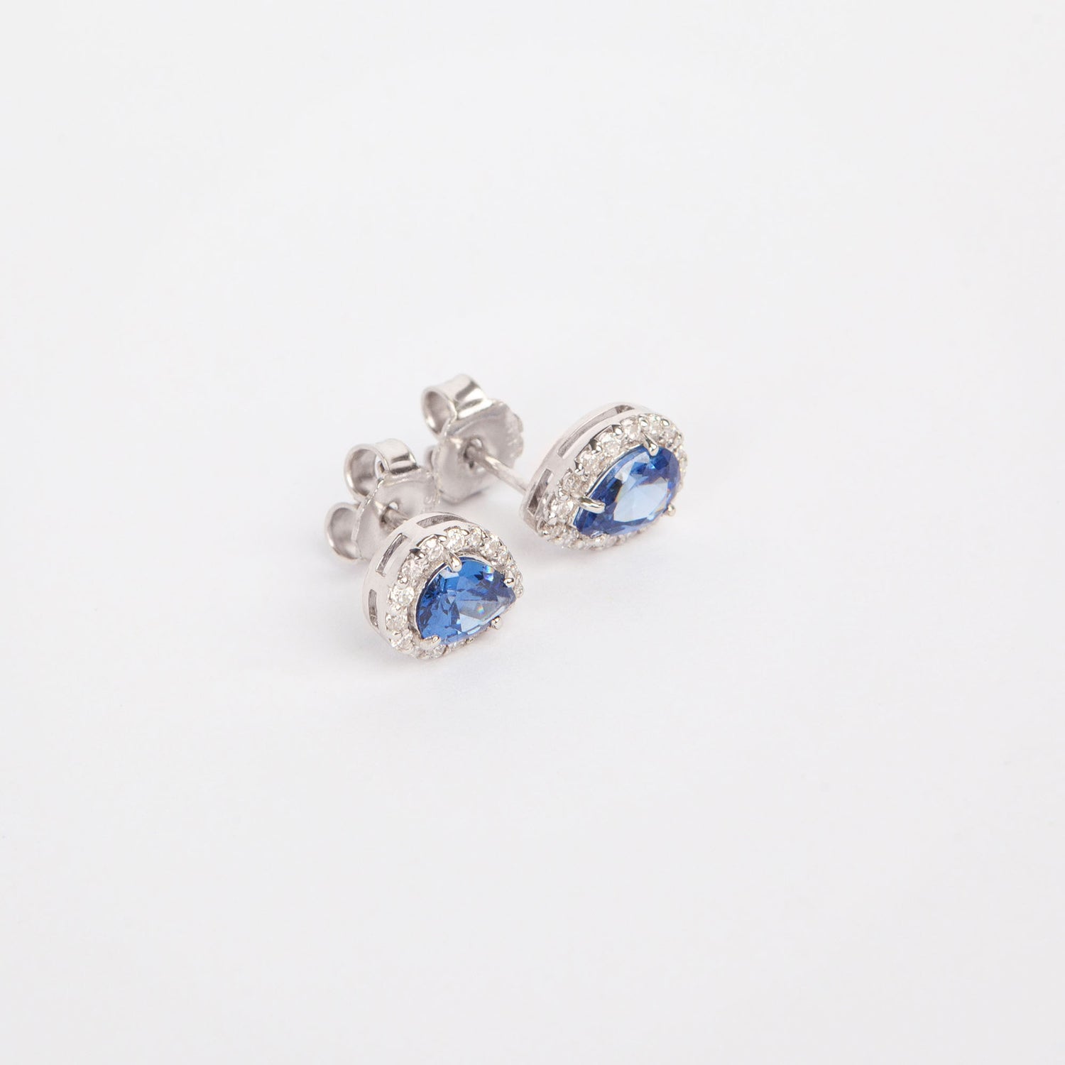14K white gold earrings featuring blue natural tanzanites and diamond accents.