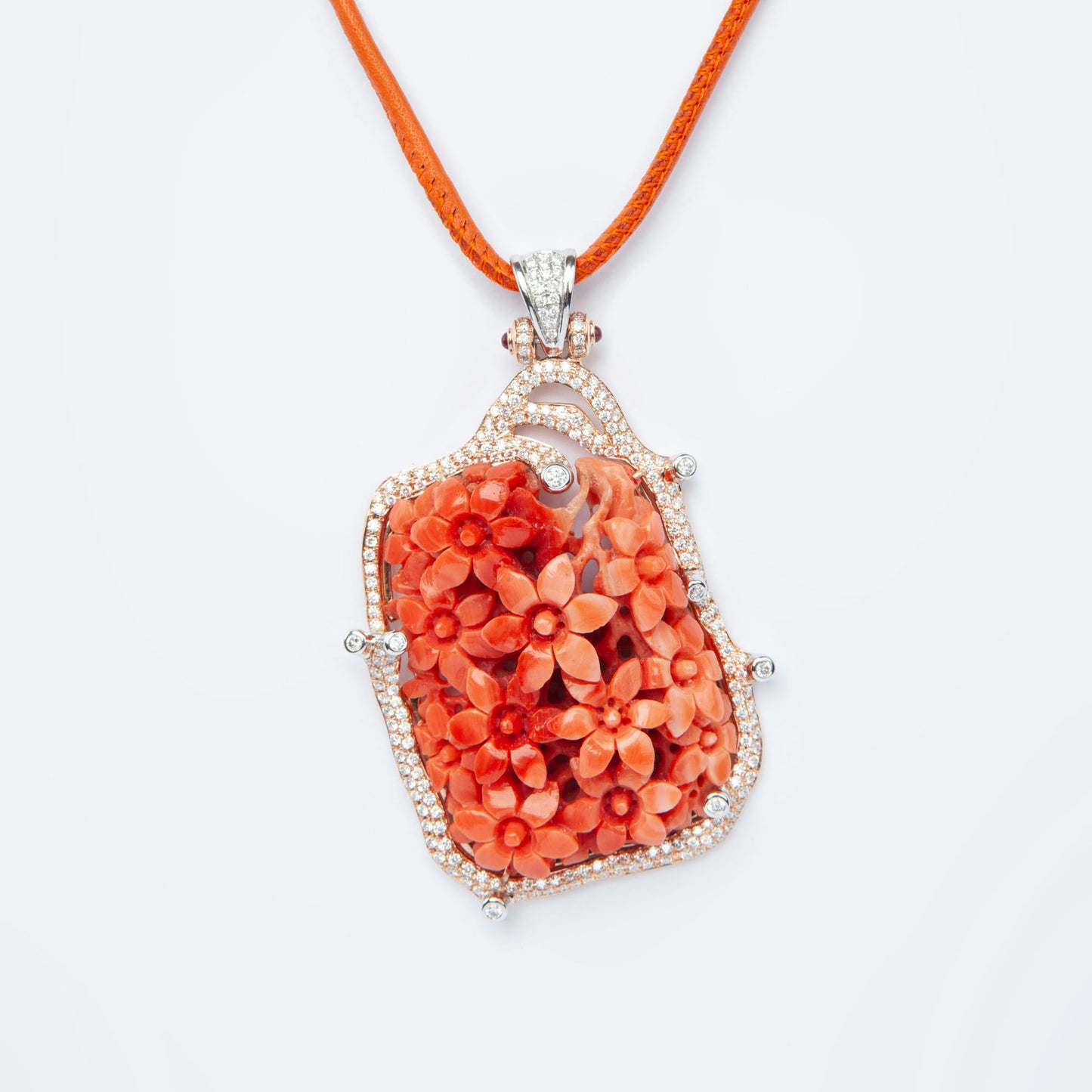 Pendant in gold featuring natural coral 81.82 ct and 231 natural diamonds 1.85 ct with ruby accent 0.12 ct.