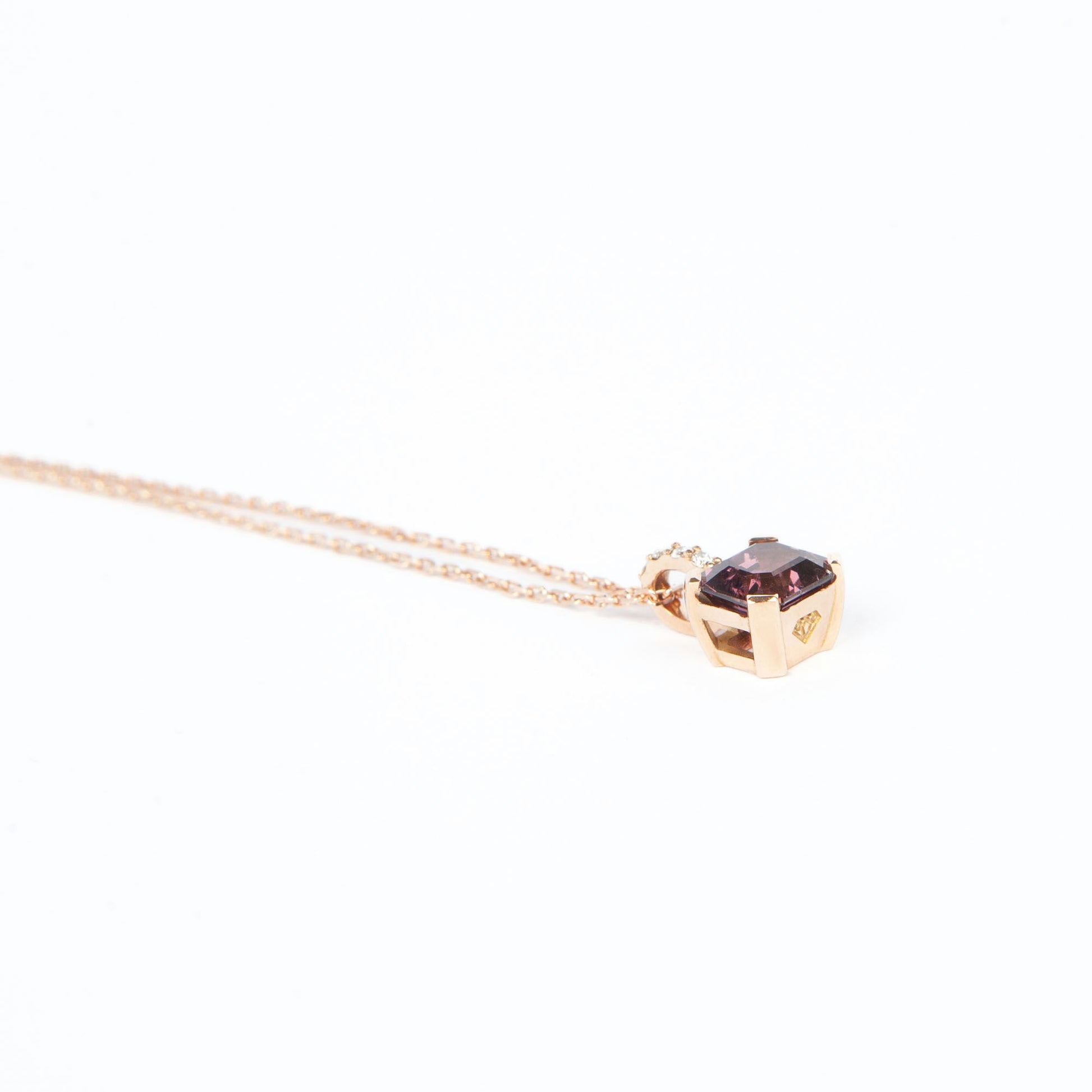 Pendant in gold featuring a natural purple spinel (1.98 ct) and four diamonds (0.04 ct) in an emerald step cut.