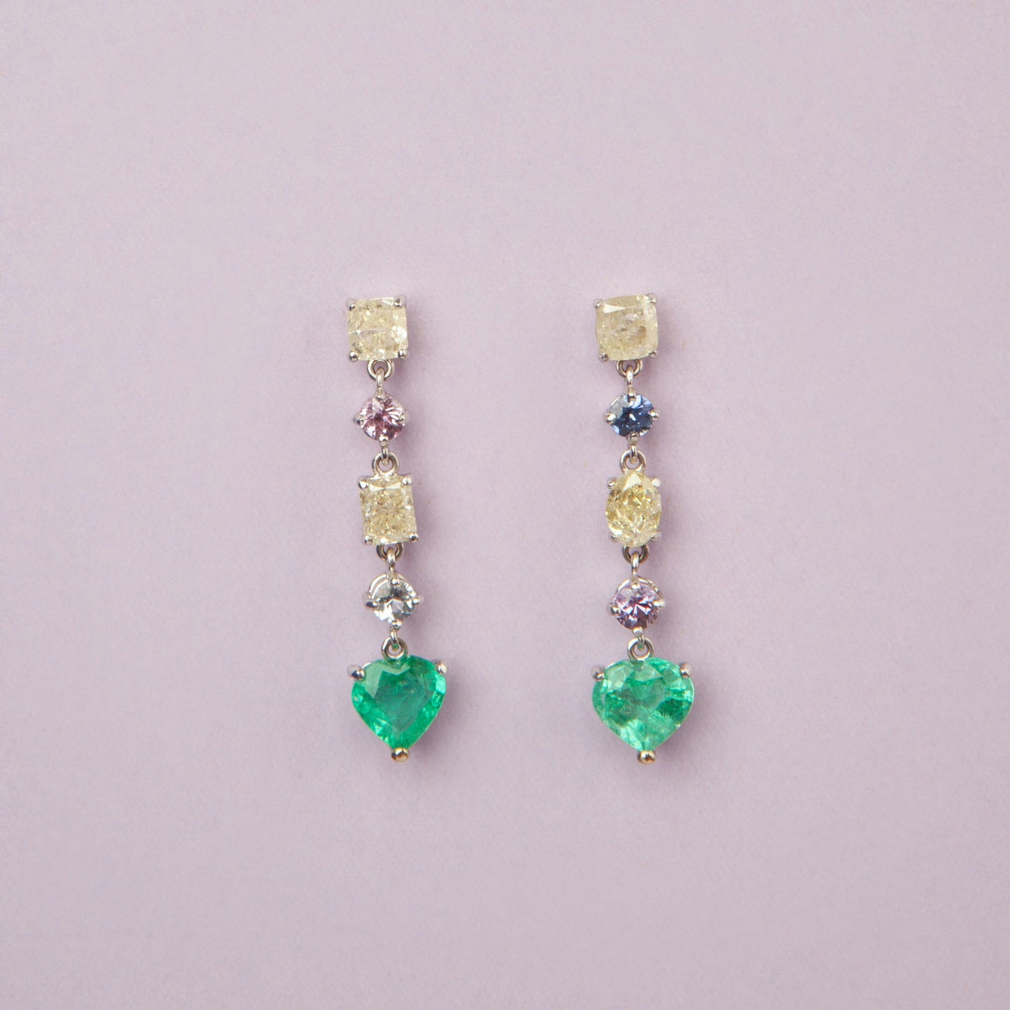 Drop earrings in 18K white gold featuring 1.669 ct heart-cut emeralds and 1.674 ct total diamonds and color sapphires.