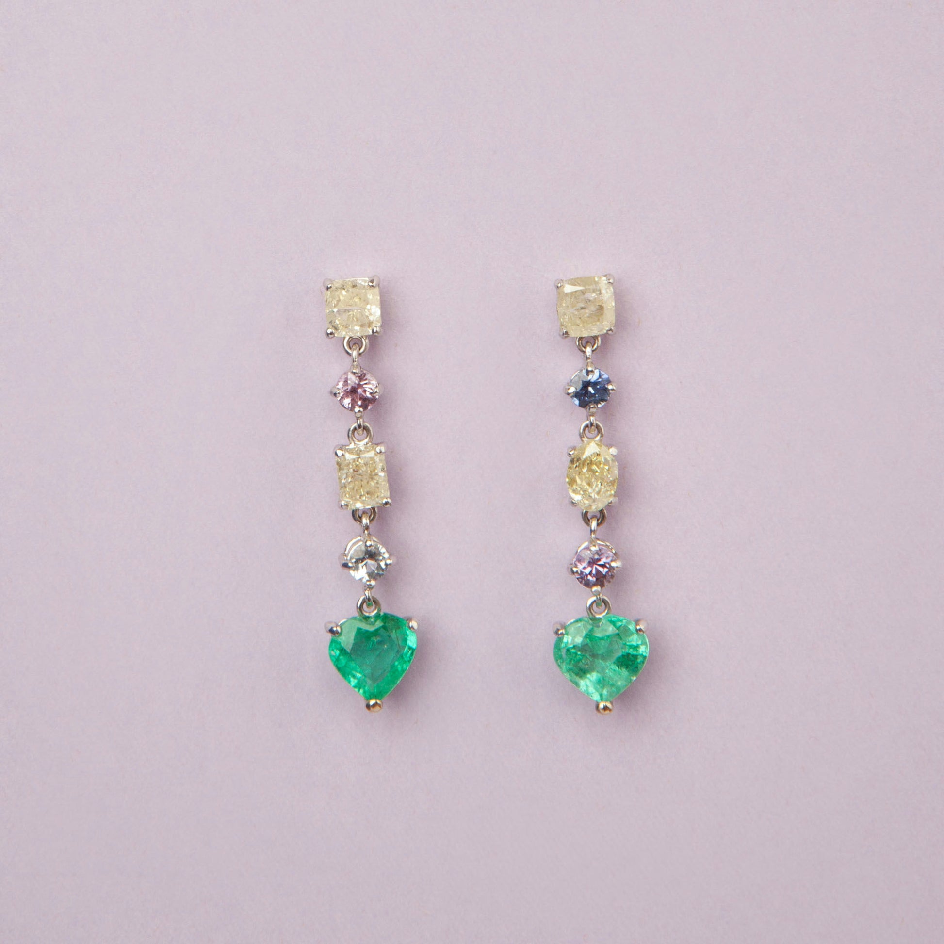 Drop earrings in 18K white gold featuring 1.669 ct heart-cut emeralds and 1.674 ct total diamonds and color sapphires.
