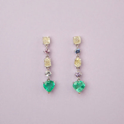 Drop earrings in 18K white gold featuring 1.669 ct heart-cut emeralds and 1.674 ct total diamonds and color sapphires.
