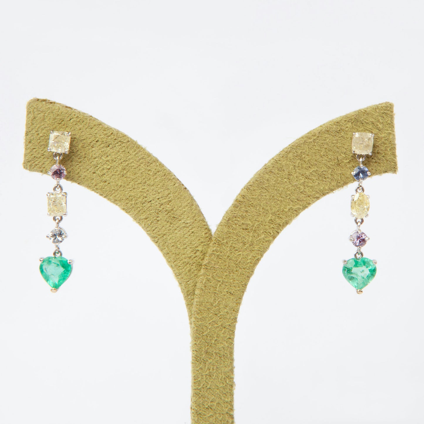 Drop earrings in 18K white gold featuring 1.669 ct heart-cut emeralds and 1.674 ct total diamonds and color sapphires.
