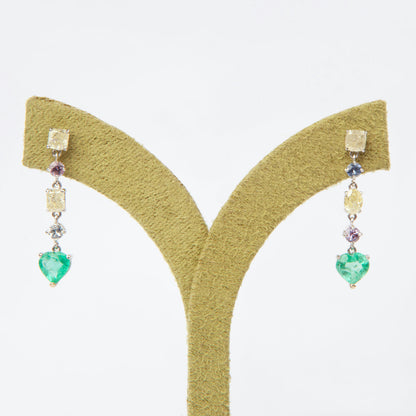 Drop earrings in 18K white gold featuring 1.669 ct heart-cut emeralds and 1.674 ct total diamonds and color sapphires.