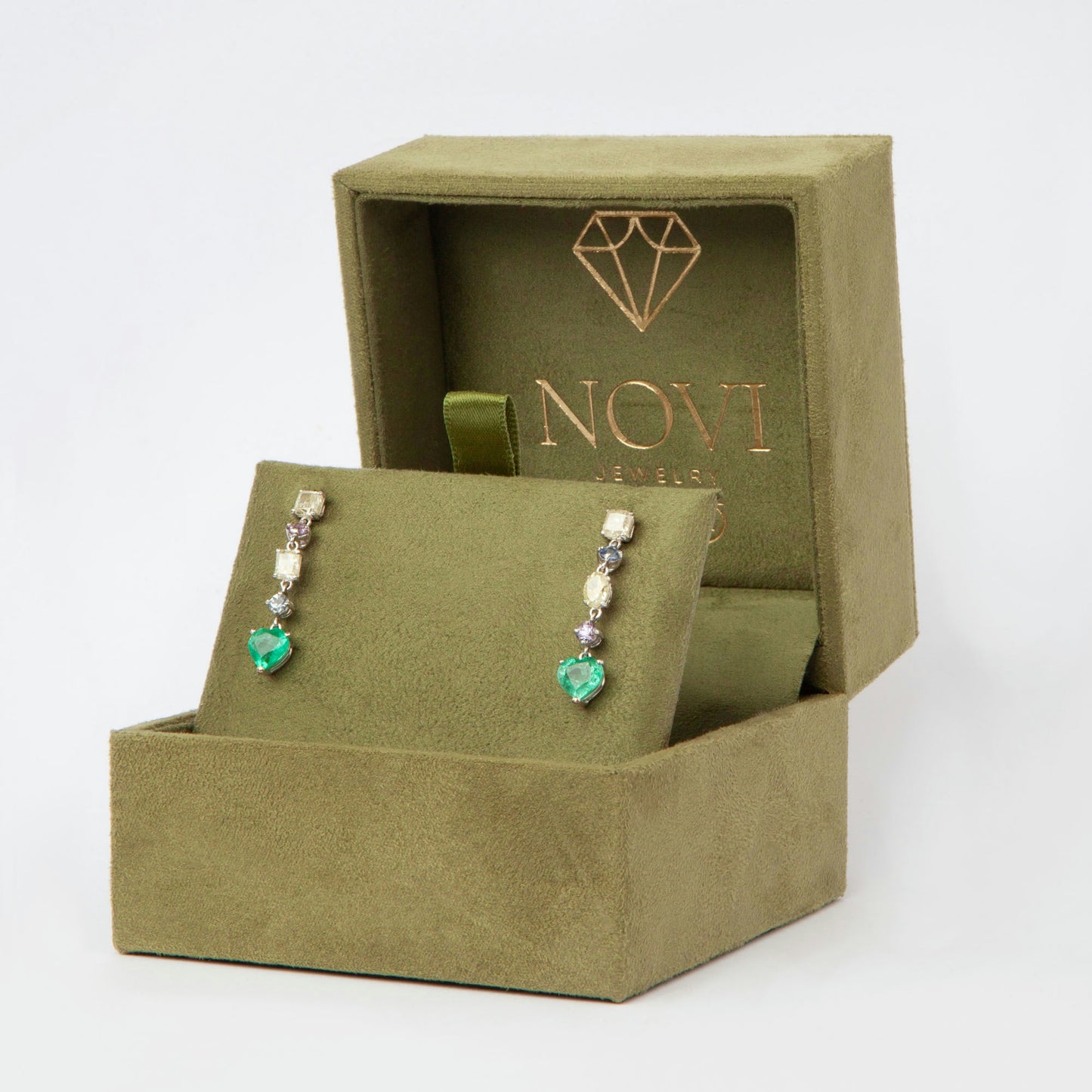 Drop earrings in 18K white gold featuring 1.669 ct heart-cut emeralds and 1.674 ct total diamonds and color sapphires.