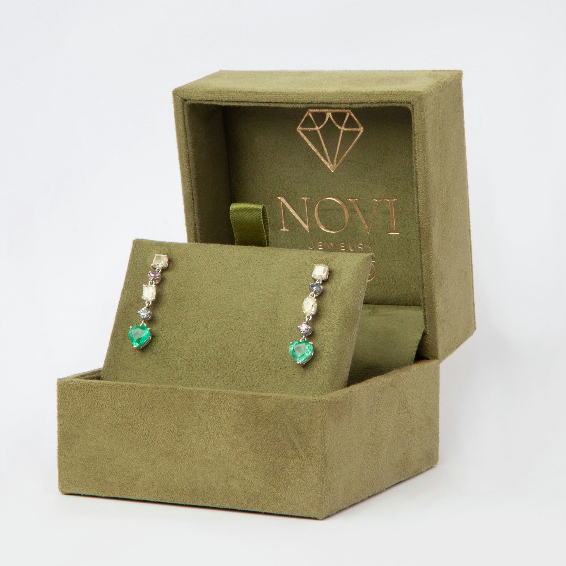 Drop earrings in 18K white gold featuring 1.669 ct heart-cut emeralds and 1.674 ct total diamonds and color sapphires.