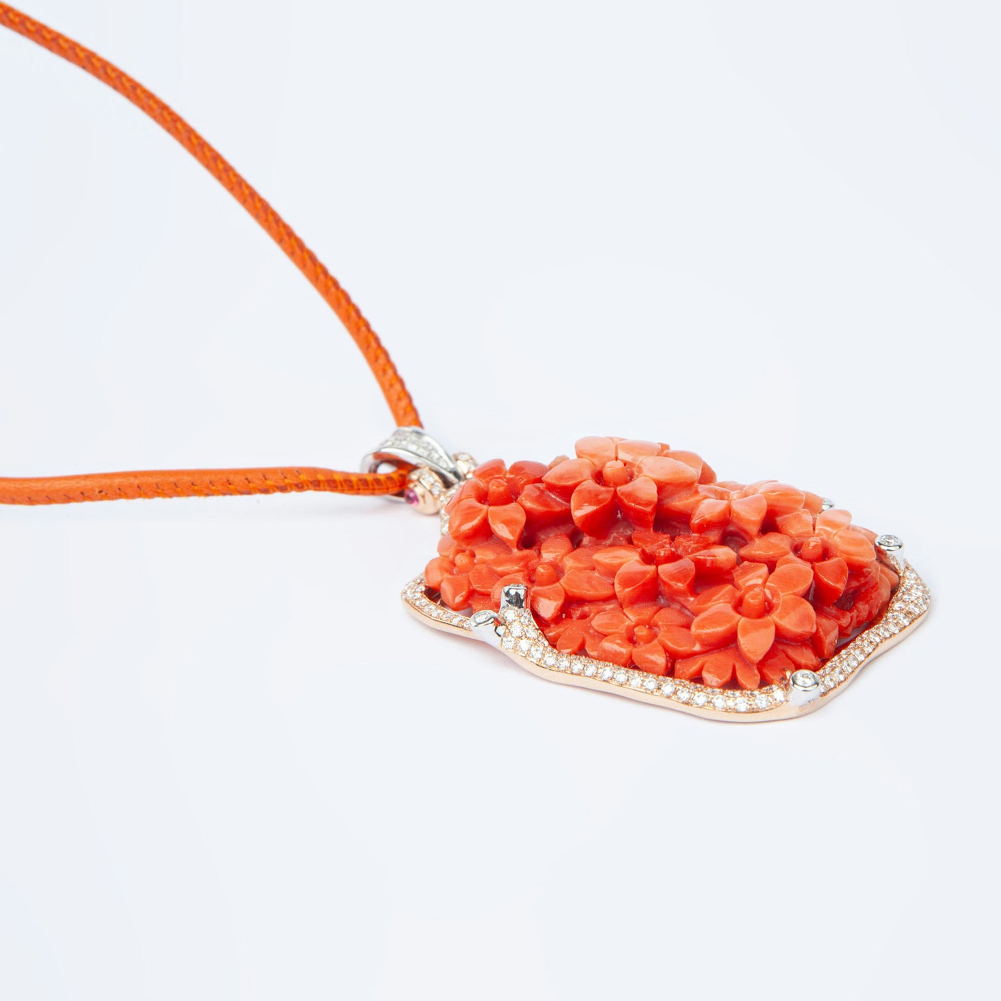 Pendant in gold featuring natural coral 81.82 ct and 231 natural diamonds 1.85 ct with ruby accent 0.12 ct.