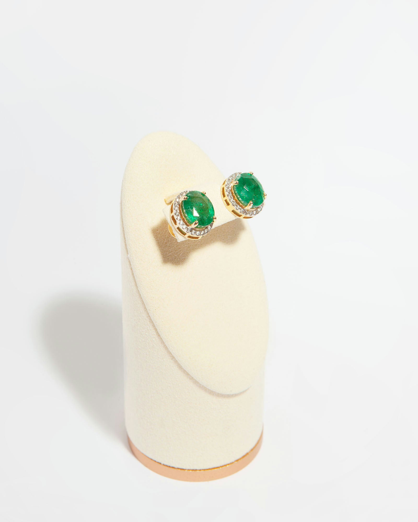 Stud earrings in 14K yellow gold featuring two oval mixed-cut natural emeralds (6.60 ct) and 51 natural diamonds (0.40 ct).